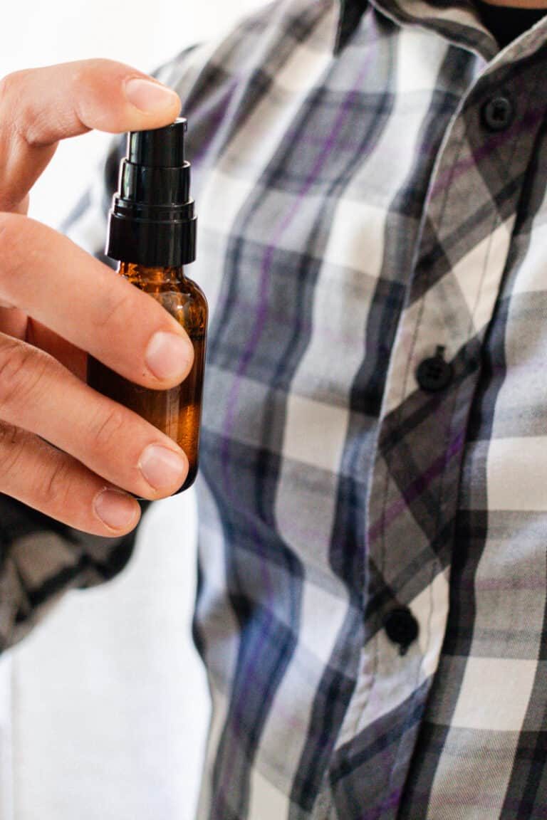 Spraying patchouli cologne at an arms distant onto our dress shirt.