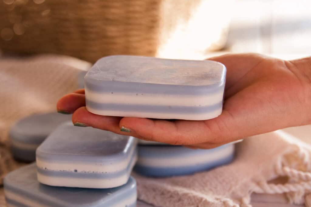 Holding a bar of layered peppermint soap.