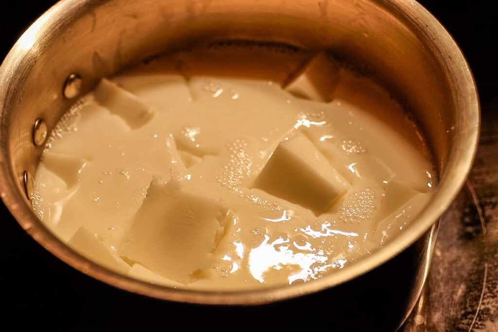 Melting soap base in a pot on the stove.