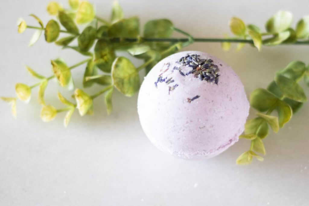 A purple bath bomb with greenery.