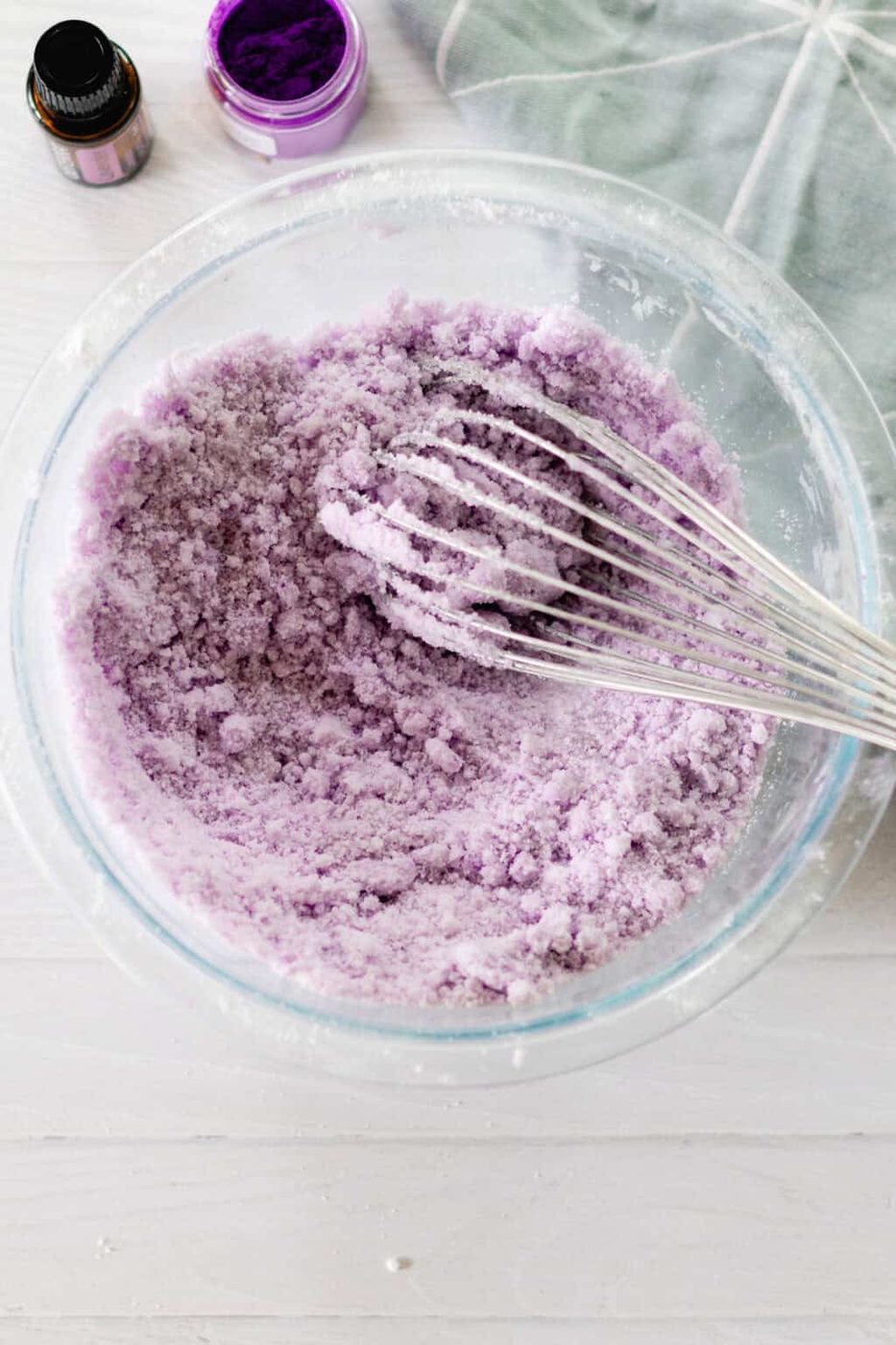Mixing the ingredients with a whisk on a white wooden table.