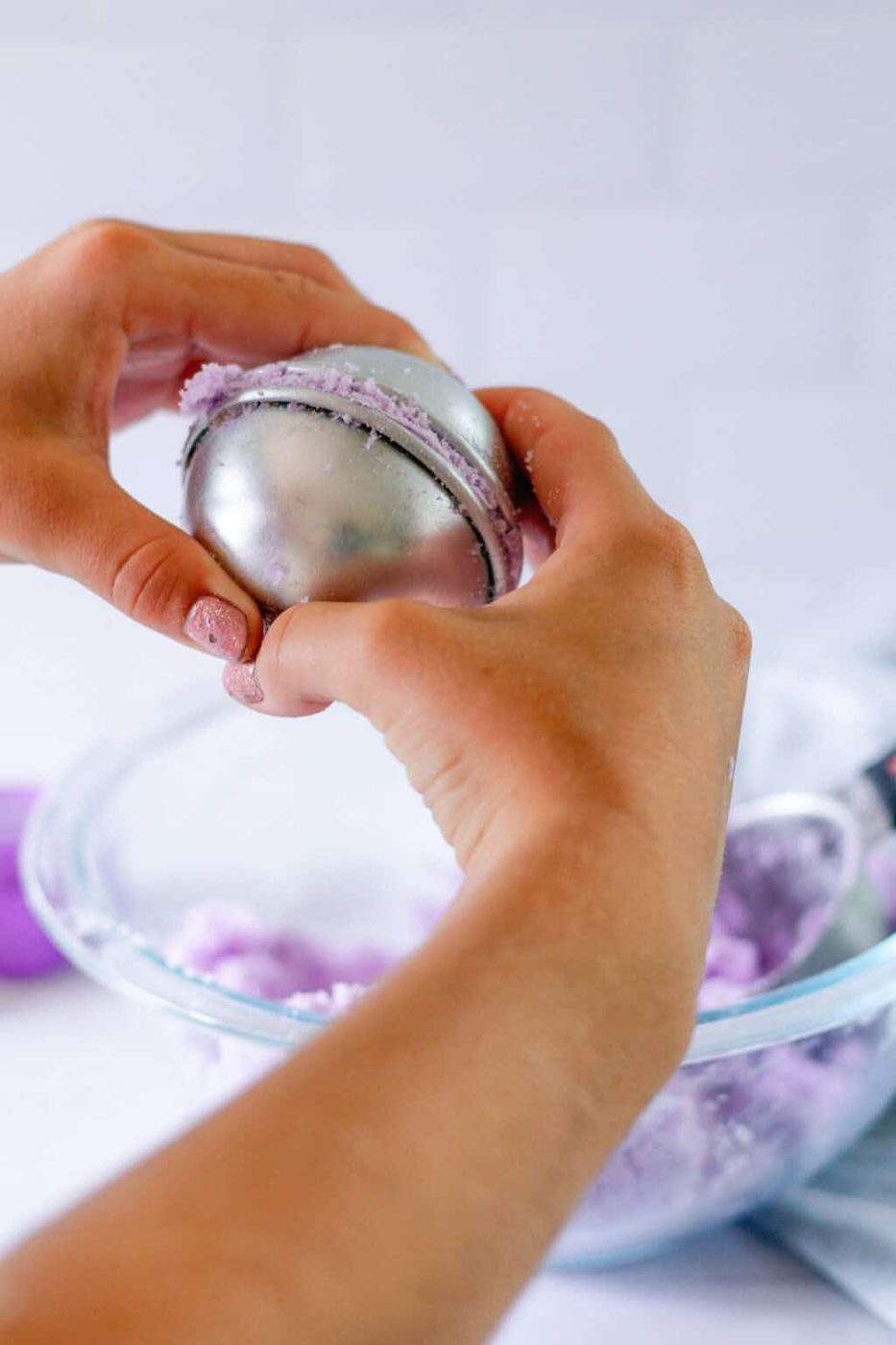 Squeezing the bath bomb molds together tightly before setting them aside to dry.