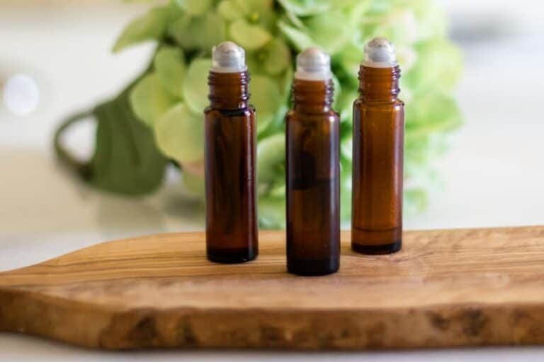 Essential oil roller bottles on wood cutting board.