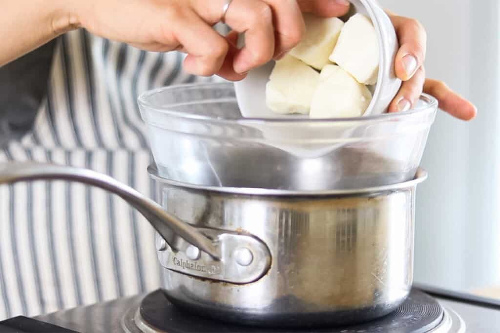 Putting shea butter chunks into a double boiler.