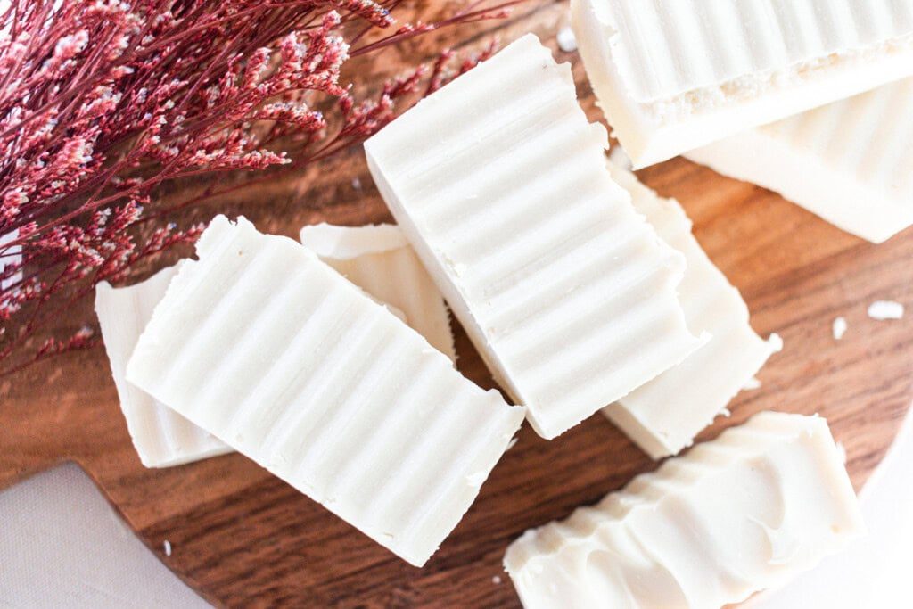 Shea butter soap bars curing on a wooden block.