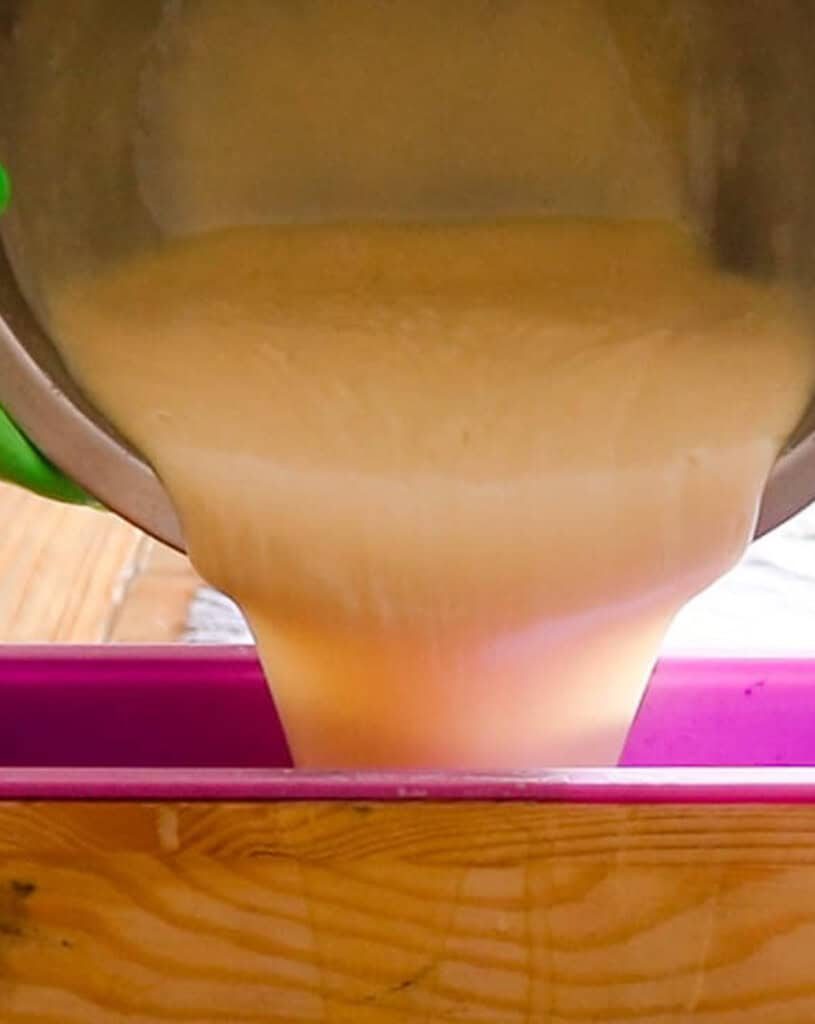 Pouring the melted cold process shea butter soap into a soap mold to cure.