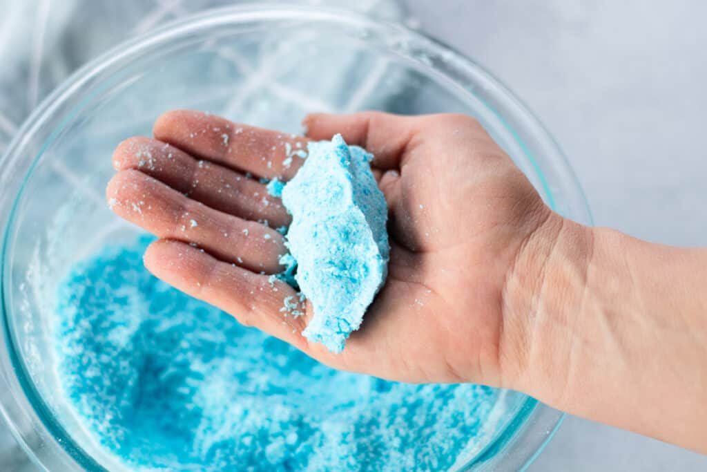 Pressing the shower bomb mixture in the palm of our hand to check for the correct consistency.