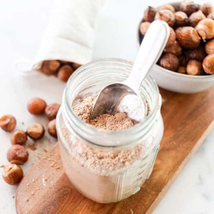 Soap nut laundry detergent in a glass storage container on a wooden shelf.