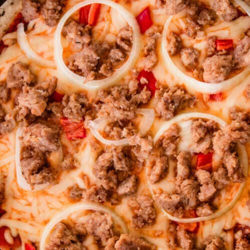 A sausage sourdough pizza in a cast iron skillet.