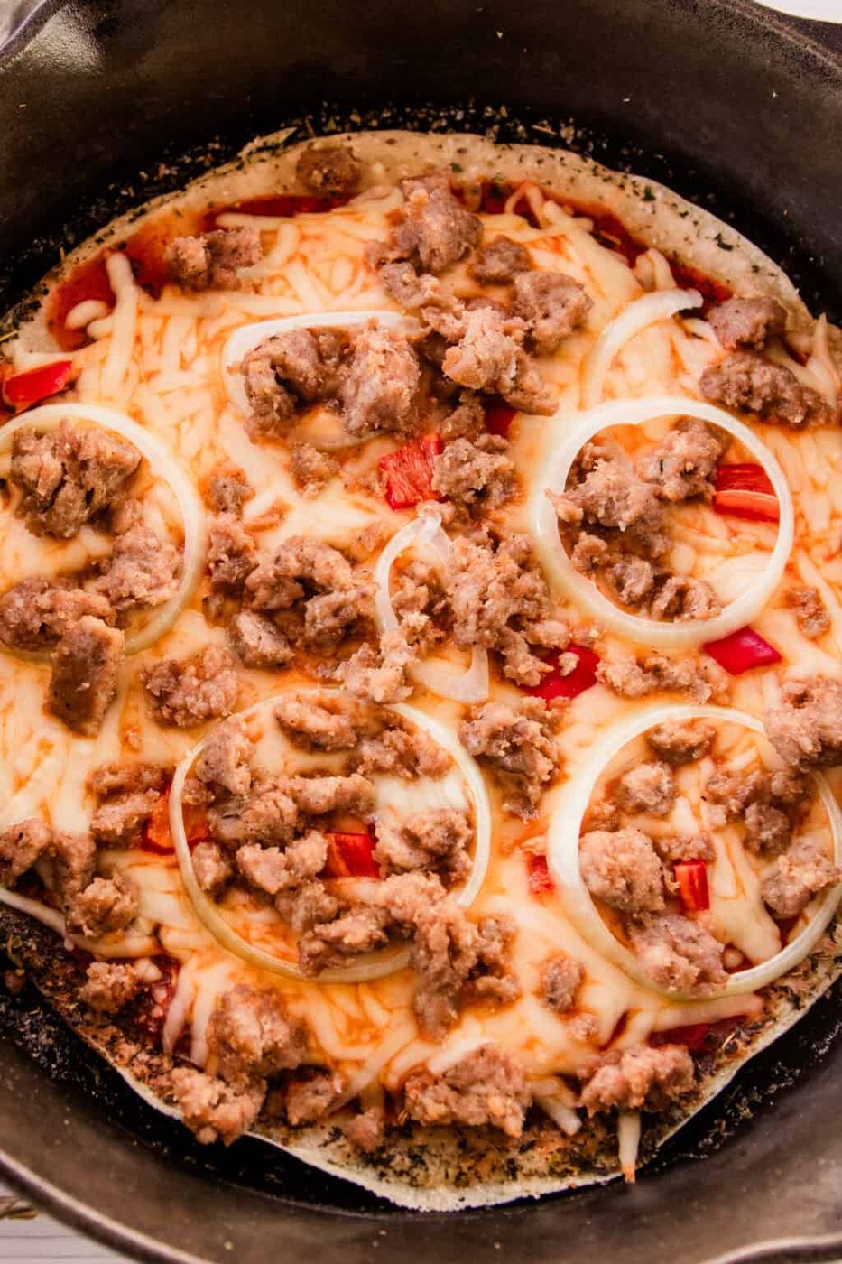 Sausage sourdough pizza fully baked in a cast iron skillet.