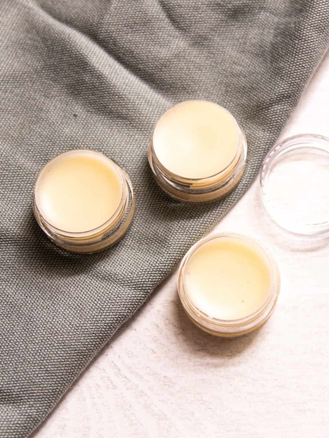 Circular containers of tallow lip balm assembled on a table.