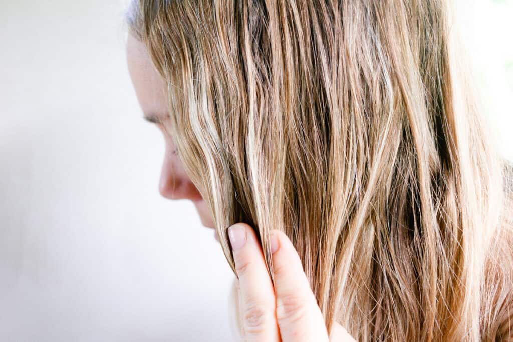 Rubbing hair moisturizing oil into our hair.