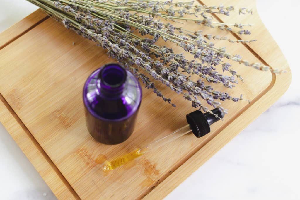 A bottle of homemade hair moisturizer with lavender sprigs alongside.