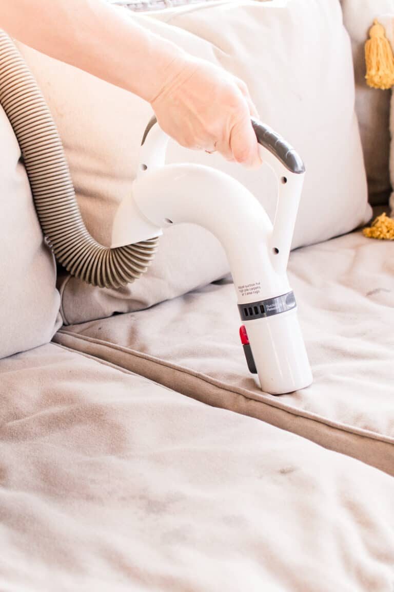 Vacuuming upholstery with a homemade cleaner.