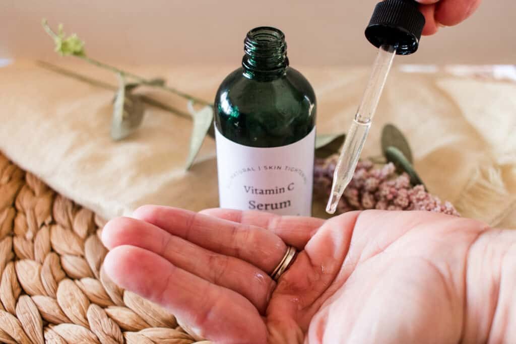 Applying vitamin C serum to the hands.