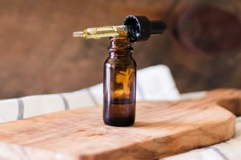 Vitamin E oil bottle with dropper lid sitting on top of it.