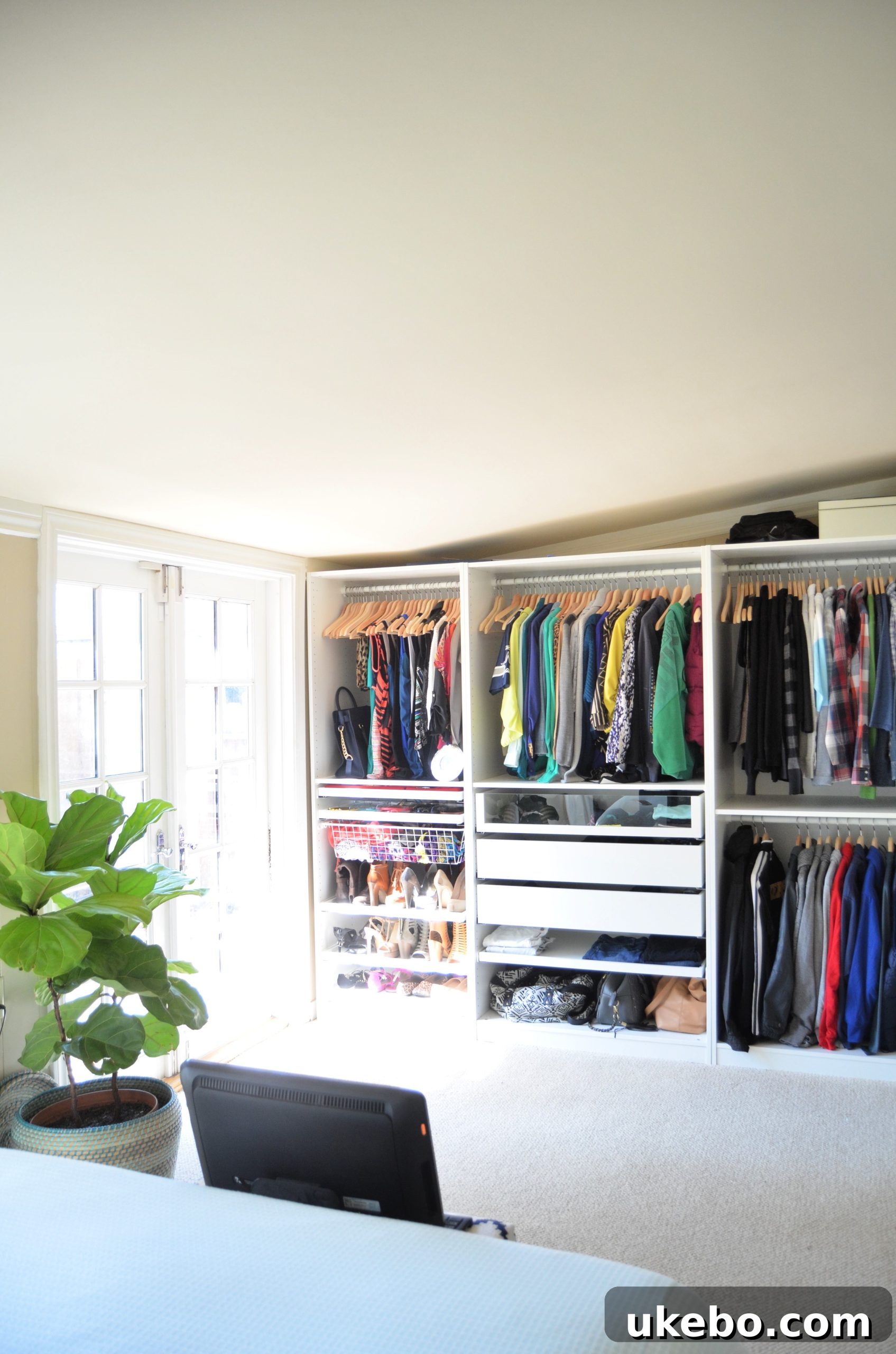Interior view of IKEA PAX closet with clothes and accessories
