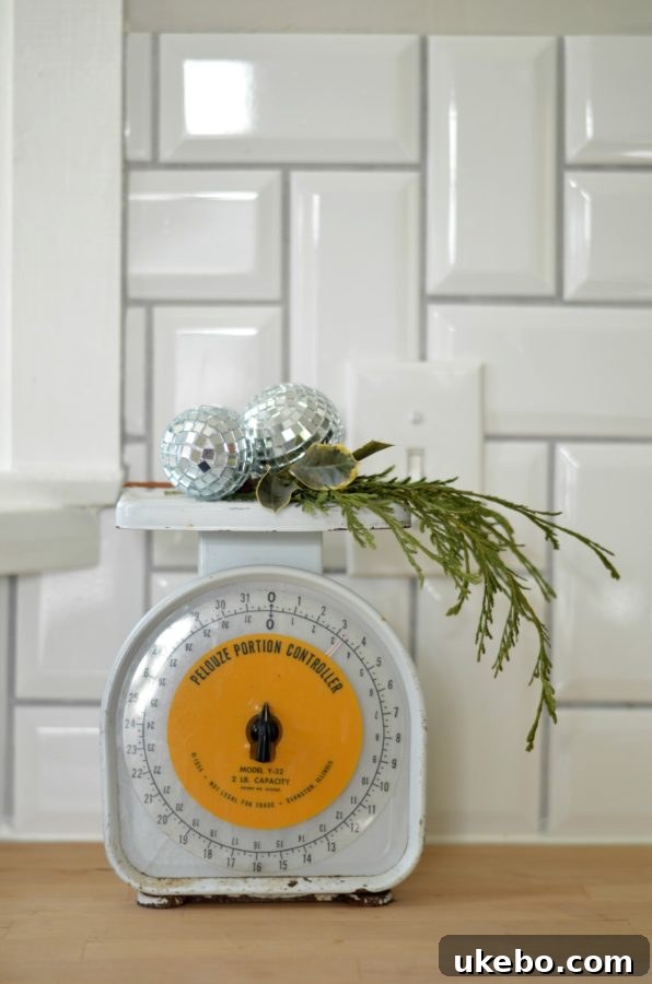 Vintage kitchen scale adorned with a sprig of festive greenery, adding character and charm