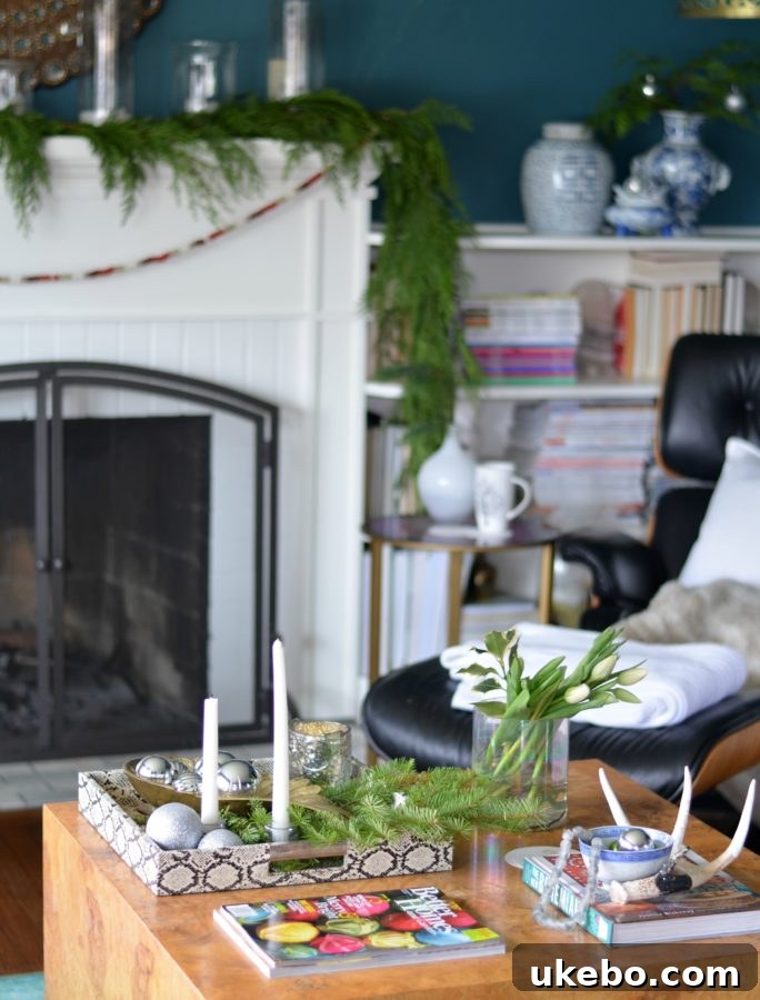 Coffee table styled with festive candles, a book, and silver holiday decor