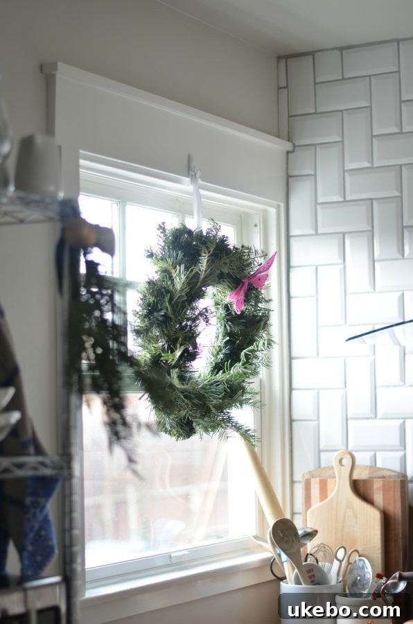 A delightful Christmas wreath adorning a kitchen window, bringing in natural beauty
