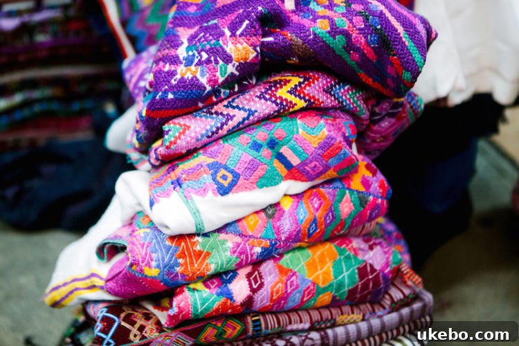 Stack of vibrant huipil textiles showcasing Guatemalan artistry and patterns.