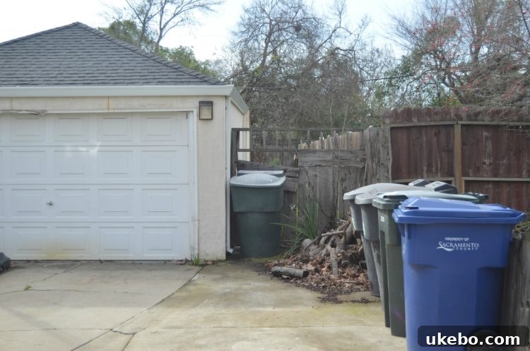 Broken gate hinges and damaged latch, illustrating the lack of security and functionality of the backyard entry.
