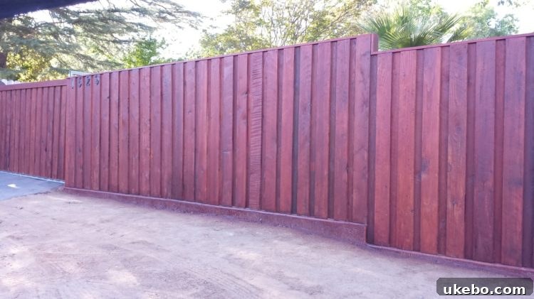 Refreshing the Cottage Bungalow's Fence Line 20 Another example of a contemporary vertical board fence with subtle modern elements, offering both security and stylish appeal.