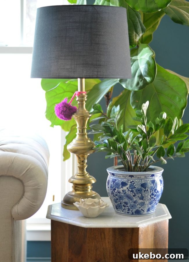 A styled side table vignette, displaying a curated collection of antique books, a unique lamp, and personal mementos.