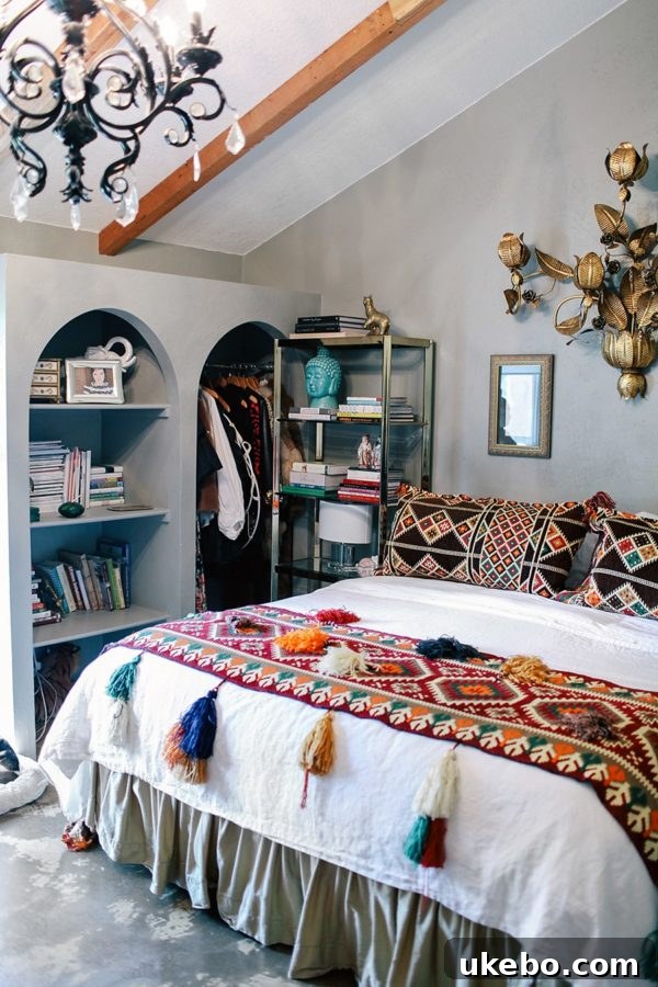 Bedroom featuring a cozy bed adorned with a throw blanket and pillows, all embellished with decorative tassels, creating a soft and inviting atmosphere.
