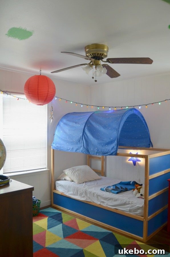 Before shot of a messy boy's room with various paint swatches on the ceiling and a tent bed