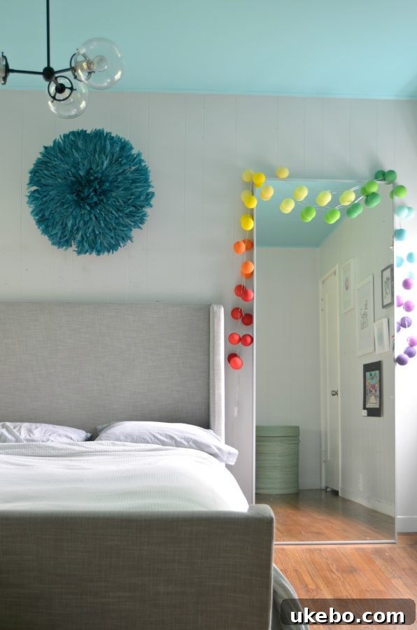 Close-up of string lights draped around a mirror in Bry's bedroom, adding a vibrant touch to the monochromatic decor.