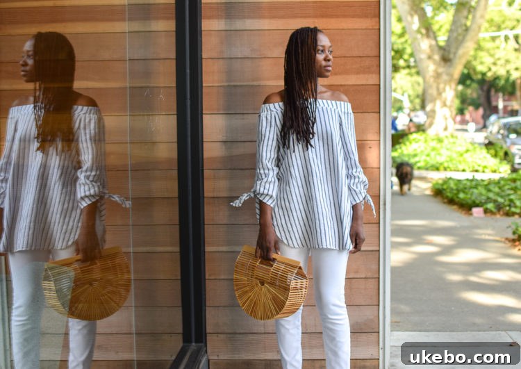 Blogger Shavonda proudly holding her new Cult Gaia Ark Bag, paired with stylish outfit
