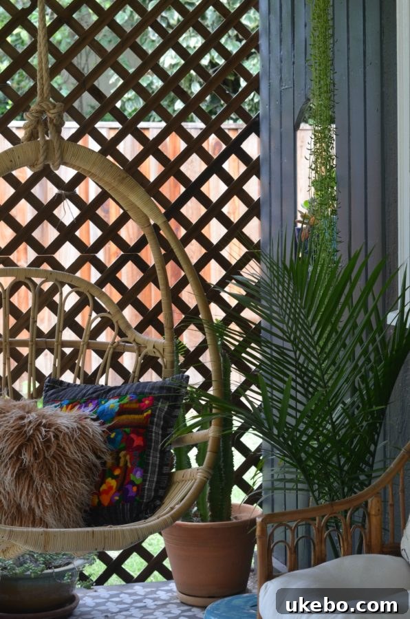 A cozy corner of the porch with a comfortable seating arrangement, throw pillows, and abundant plant decor.