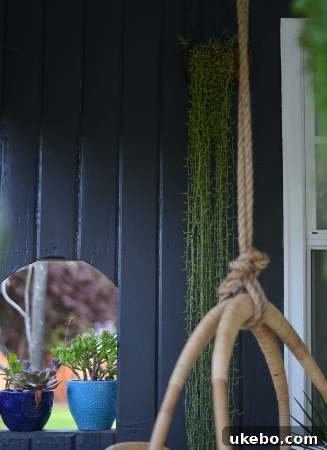 An inviting outdoor hammock draped with a cozy blanket, nestled amidst lush foliage on a small, charming porch.