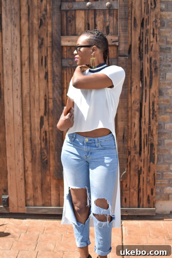 Close-up of a high-low top and distressed denim, showcasing casual elegance.