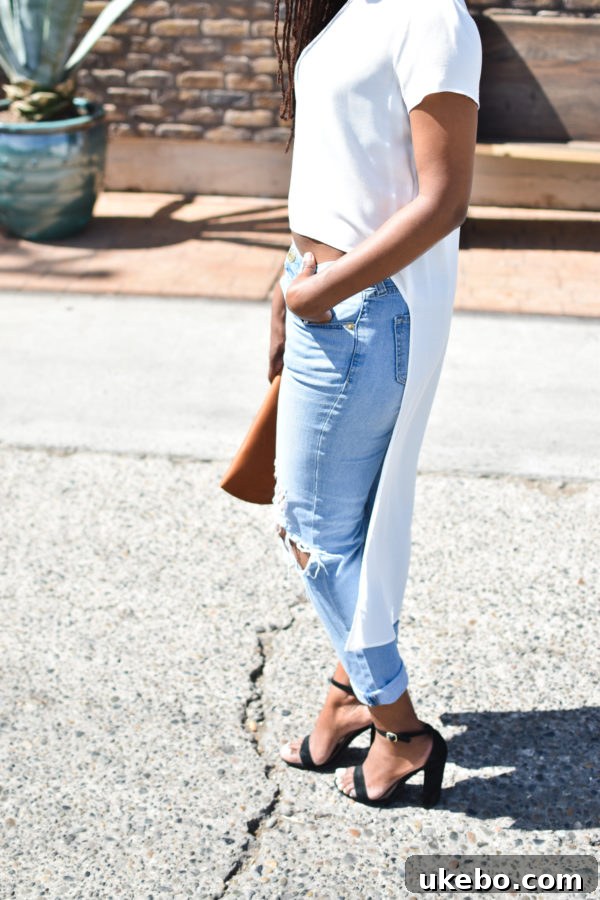 Detailed shot of the ripped jeans and chunky velvet heels, a perfect blend of edgy and chic.