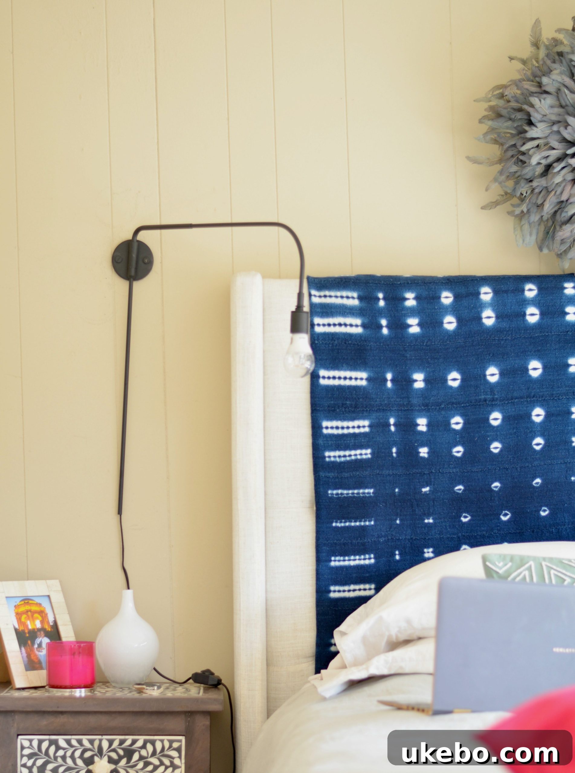 View of the bedside area showcasing the space-saving benefits of the wall-mounted sconce, freeing up nightstand space.