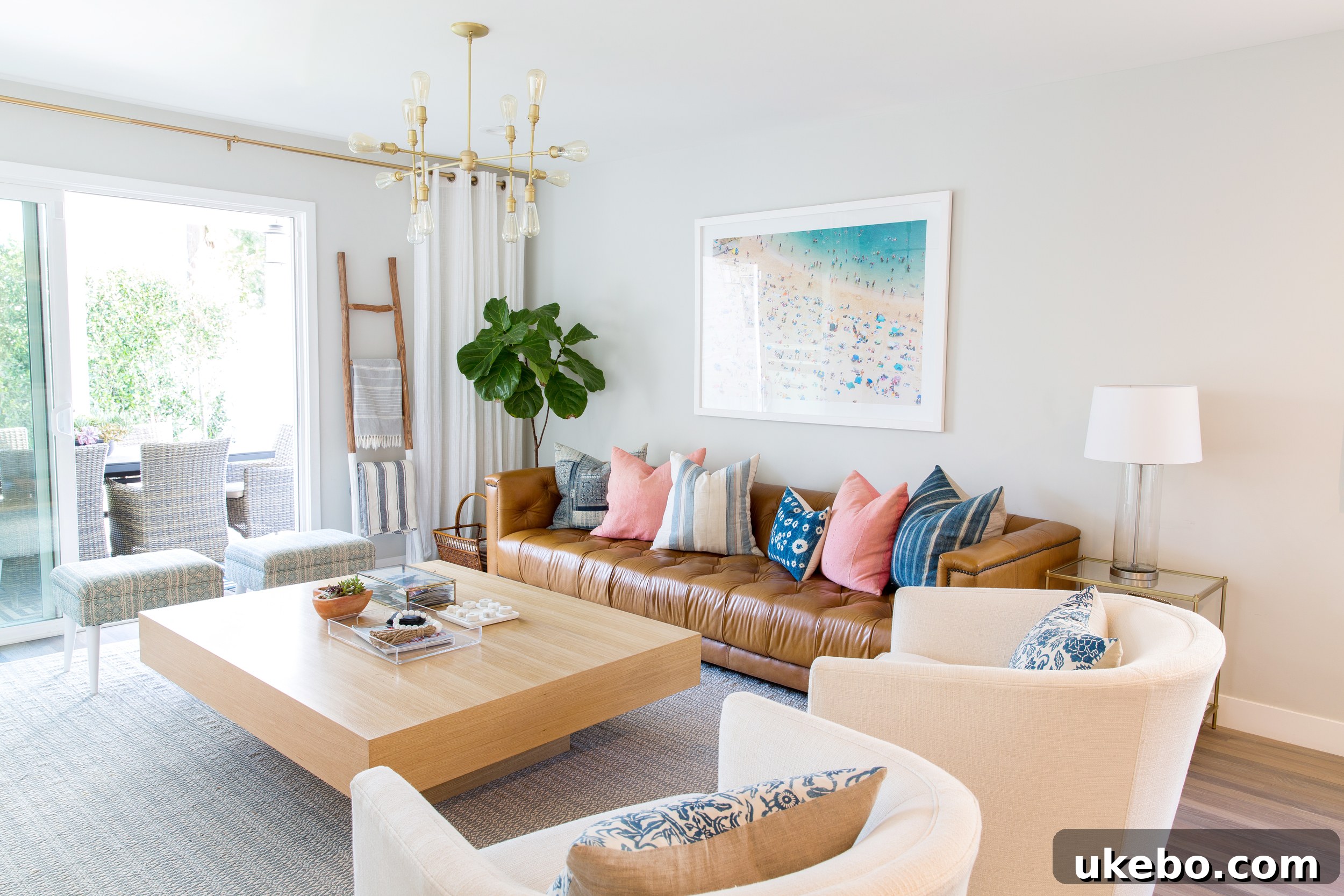 Tan Leather Sofa A Design Muse 3 Bright and airy living room featuring a tan leather sofa against a white wall, with a large window letting in natural light.