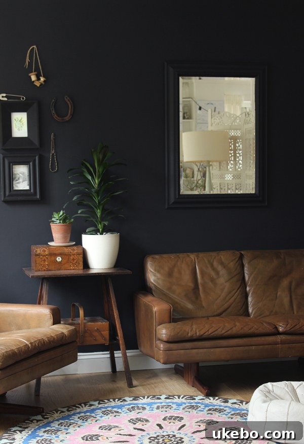 Tan Leather Sofa A Design Muse 6 Moody living room with a tan leather sofa against a dark wall, creating a dramatic and cozy atmosphere.