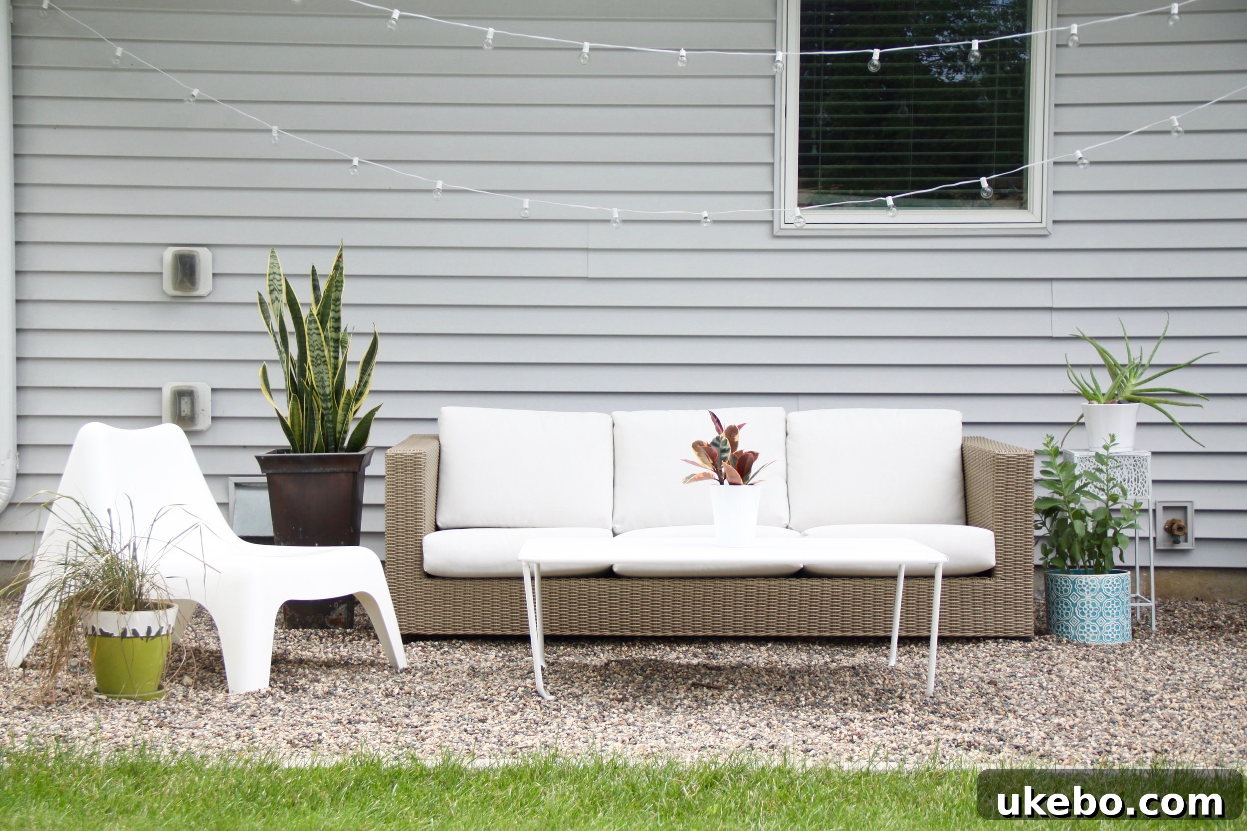 Modern pea gravel patio with outdoor dining furniture and lush plantings
