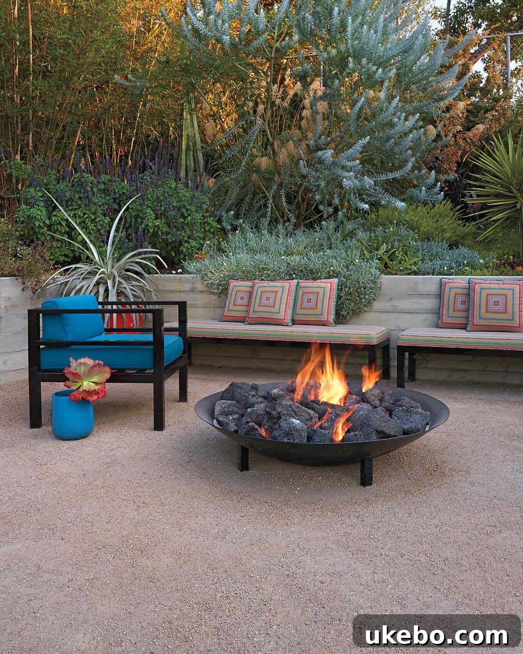Decomposed granite pathway leading through a garden with a fire pit area