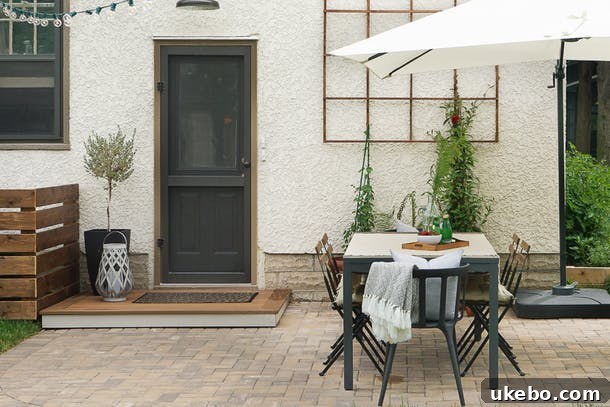 Neatly laid brick paver patio with a dining set and potted plants