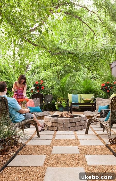 Paver patio with a central pea gravel fire pit area, surrounded by lush landscaping