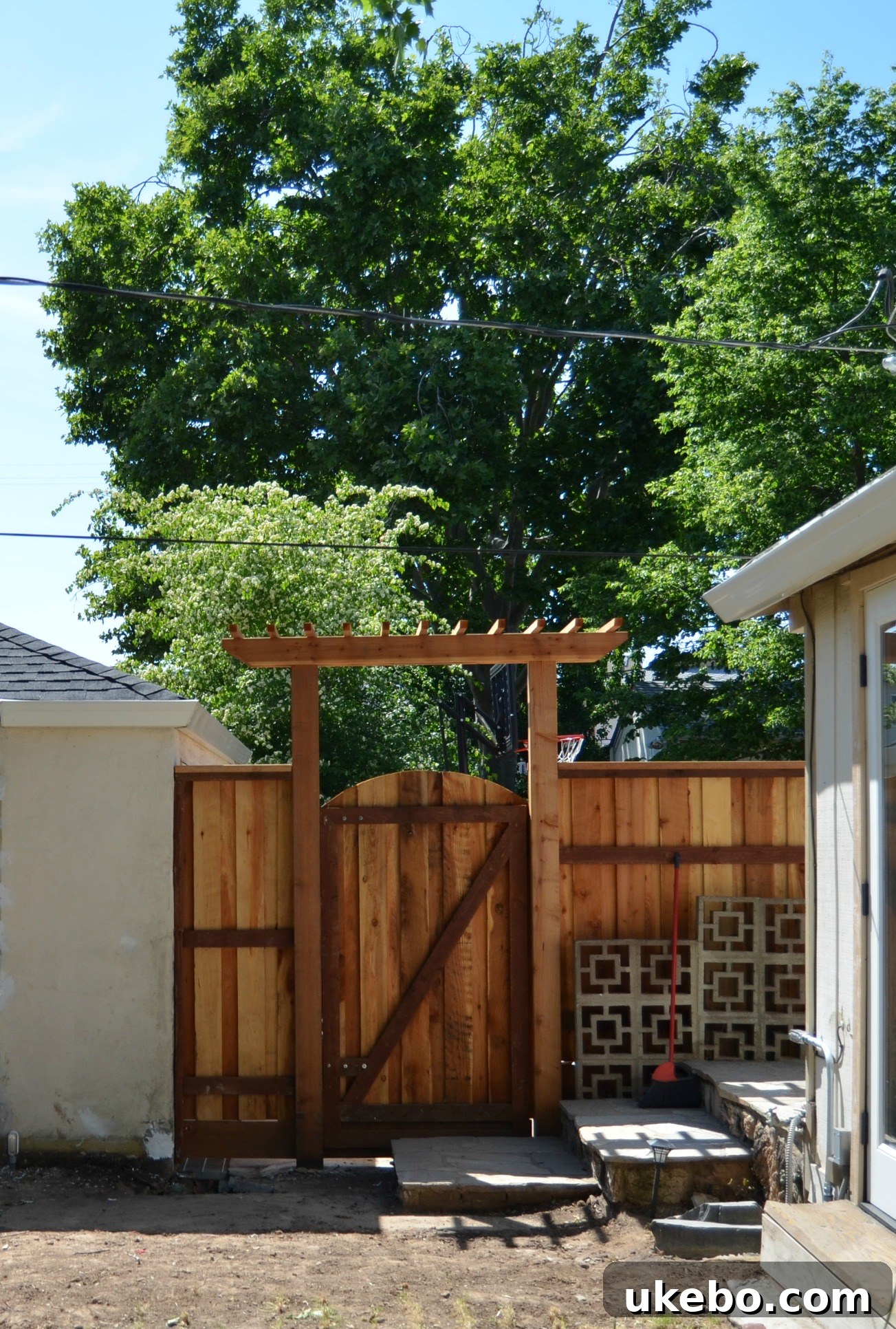 A perspective looking through the new gate and arbor into the backyard.