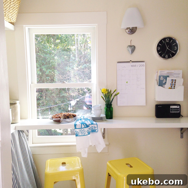 A simple breakfast bar built across a kitchen window, offering a bright spot for eating or homework, illustrating smart space utilization.