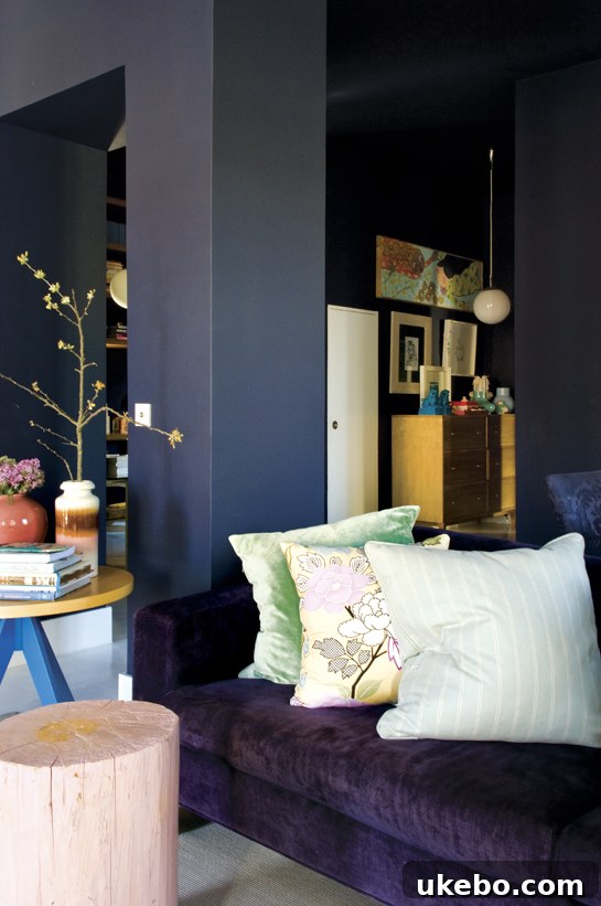An elegant bedroom featuring deep purple walls and luxurious textiles, creating a sophisticated and cozy atmosphere.