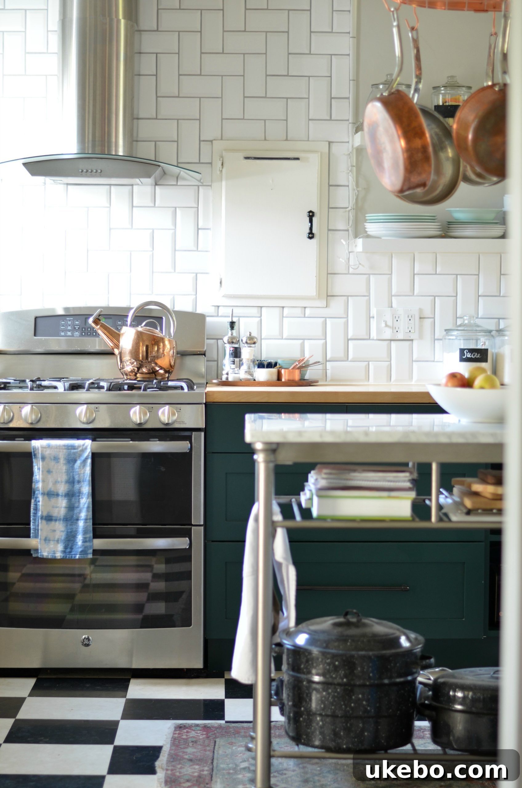 Close-up of copper pots and green kitchen cabinets