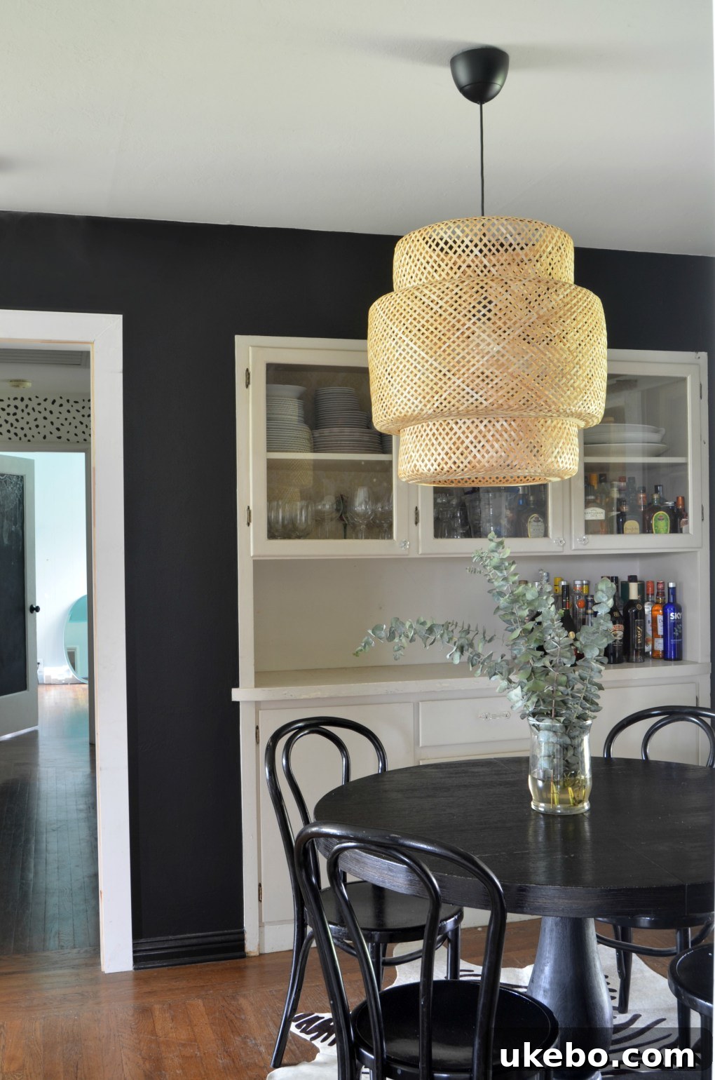 Dining room with black walls, new pendant light, and barn door.