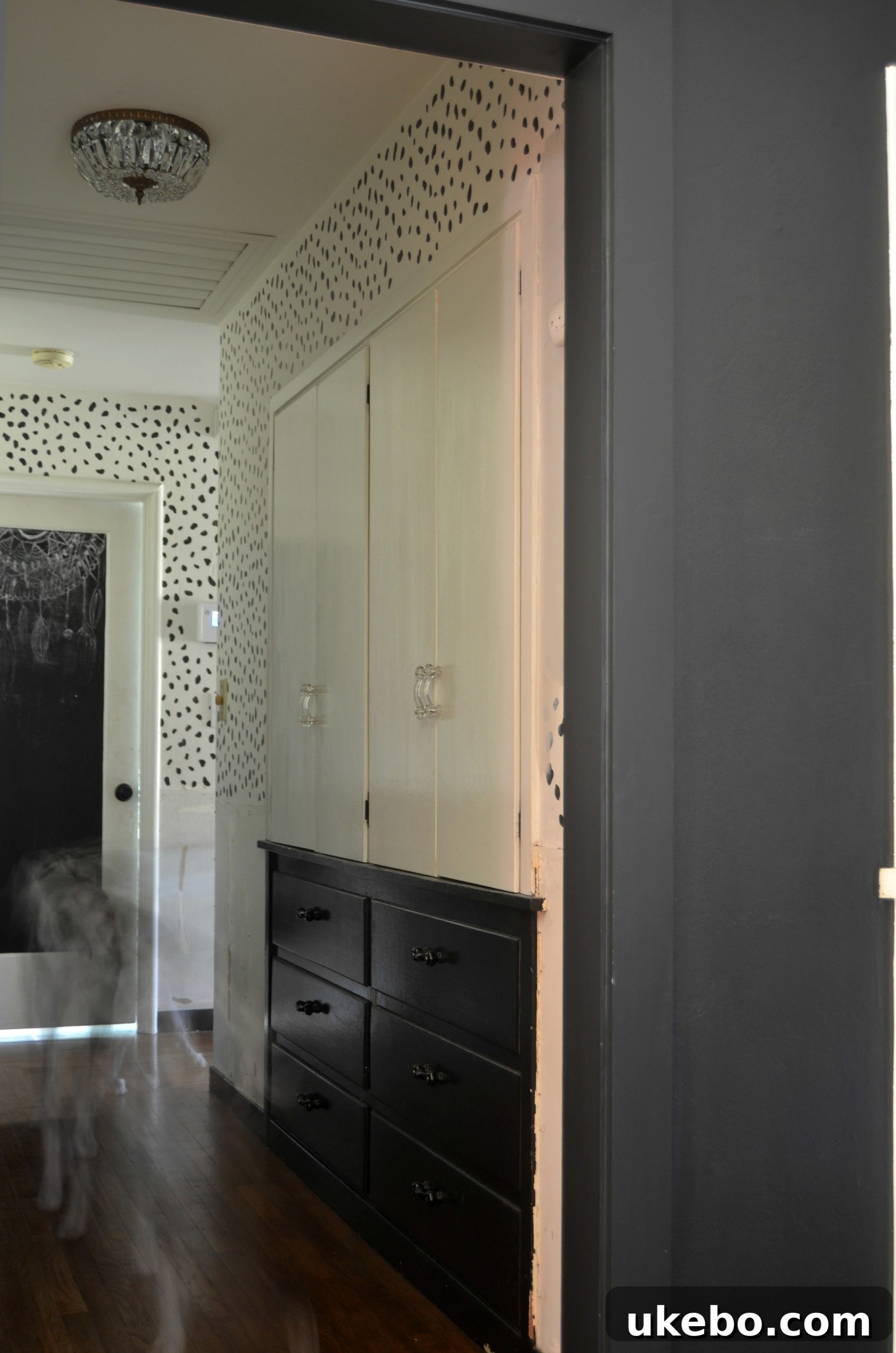 Another angle of the redesigned hallway, focusing on the vintage lighting and its contribution to the home's character.