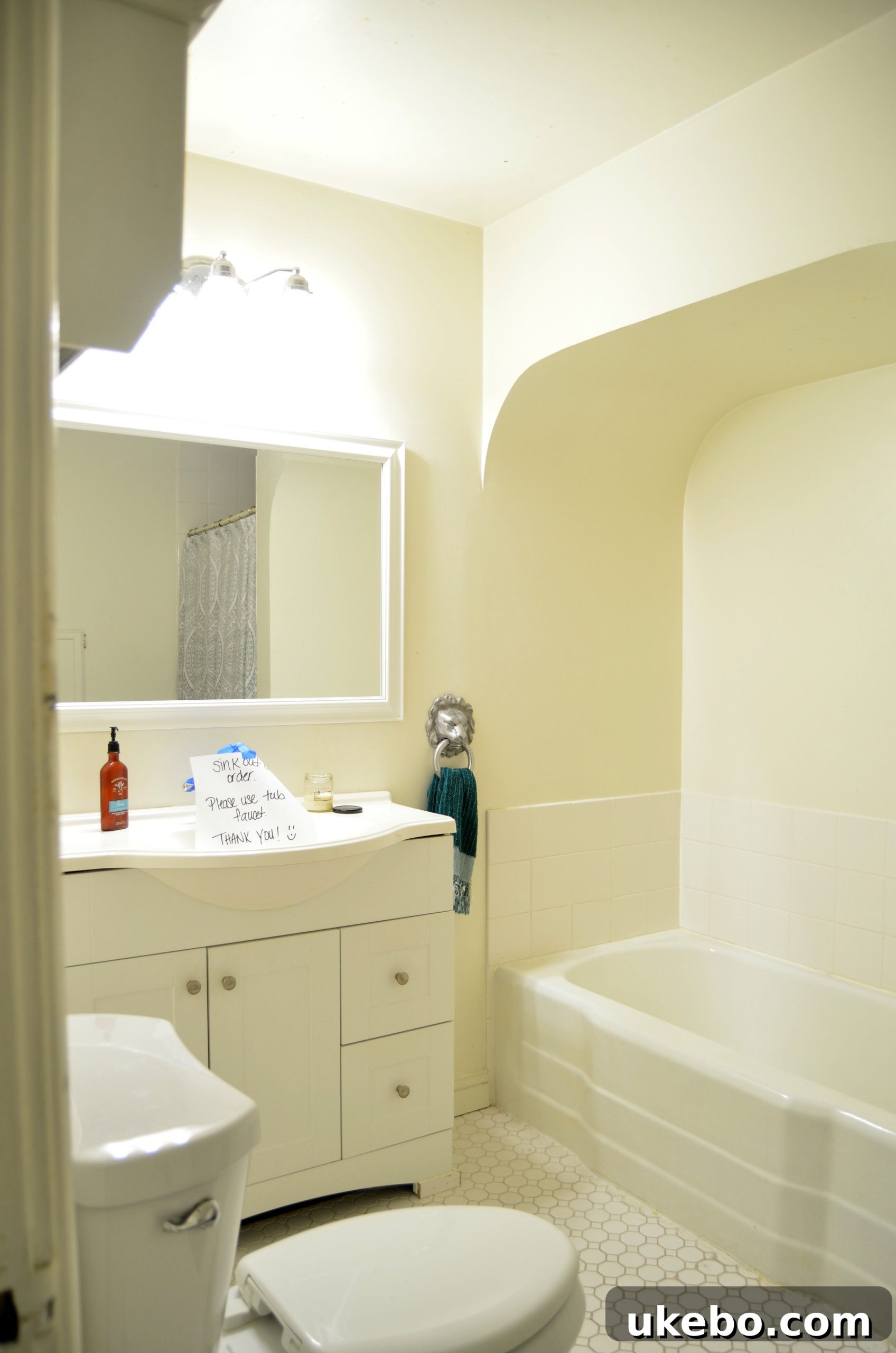 Before photo of the bathroom featuring the shower/tub combo